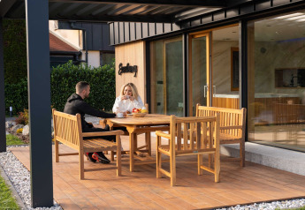 Dos personas disfrutan de bebidas en la terraza del Elegant Warm Bliss Hideaway Escape Lodge en Eslovenia.