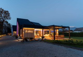 Evening view of Elegant Warm Bliss Hideaway Escape Lodge in Slovenia, featuring modern design and a lit terrace.