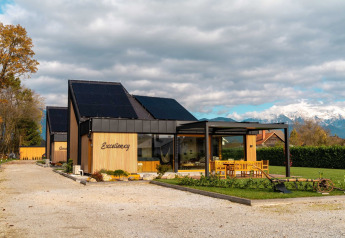 Afbeelding van Elegant Warm Bliss Hideaway Escape Lodge met zonnepanelen en zicht op bergen in Slovenië.