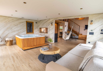 Elegante Lodge in Slowenien mit Whirlpool, stilvollem Wohnzimmer, Hängesessel und moderner Einrichtung.