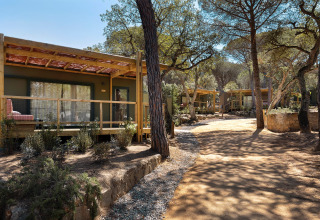 Chalets en bois avec terrasse dans la forêt à Wecamp Santa Cristina, parc de vacances en Catalogne, Espagne.