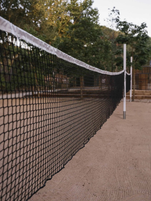 Close-up van een volleybalnet op zand bij Wecamp Santa Cristina, een vakantiepark in Catalonië, Spanje.