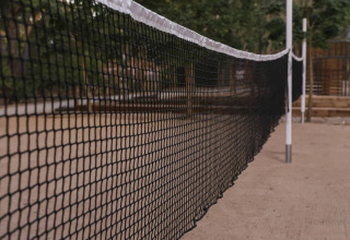 Primer plano de una red de voleibol sobre arena en Wecamp Santa Cristina, parque vacacional en Cataluña, España.