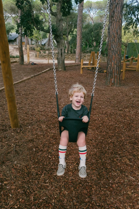 Un niño pequeño se divierte en un columpio en Wecamp Santa Cristina, un parque de vacaciones en Cataluña, España.