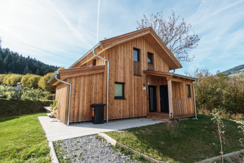Holzchalet Kreischberg Chalets 29 mit moderner Architektur, umgeben von Natur und blauem Himmel im Grünen.