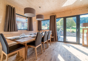 Salle à manger lumineuse en bois avec grandes fenêtres et vue, Kreischberg Chalets 29, Autriche.
