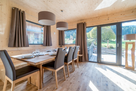Helles Esszimmer aus Holz mit großen Fenstern und Naturblick, Kreischberg Chalets 29 in Österreich.