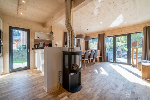 Helles, modernes Chalet Kreischberg Chalets 29 mit Kamin, Esstisch und großen Fenstern in Österreich.
