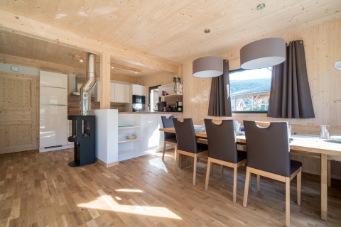 Helles, modernes Esszimmer und Küche aus Holz im Kreischberg Chalets 29 in Österreich, mit großen Fenstern.