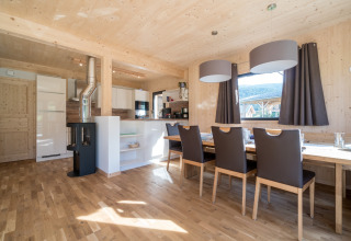 Helles, modernes Esszimmer und Küche aus Holz im Kreischberg Chalets 29 in Österreich, mit großen Fenstern.