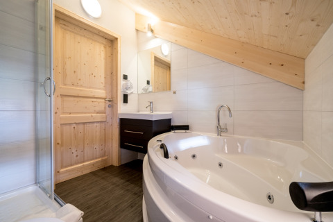 Modernes Badezimmer mit Whirlpool und Holzdekor, Kreischberg Chalets 29, Österreich.
