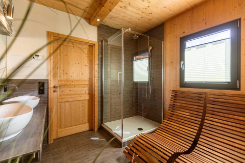 Modernes Badezimmer im Chalet mit Holzausstattung, Dusche, Fenster und zwei Waschbecken in Österreich