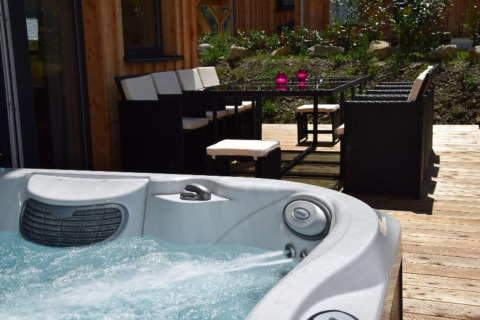 Whirlpool und Terrasse mit Essbereich bei Kreischberg Chalets 29 in Österreich, sonniger Tag draußen.