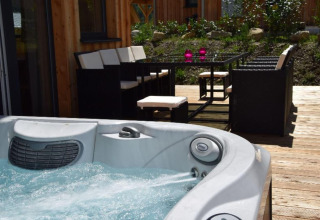 Whirlpool und Terrasse mit Essbereich bei Kreischberg Chalets 29 in Österreich, sonniger Tag draußen.