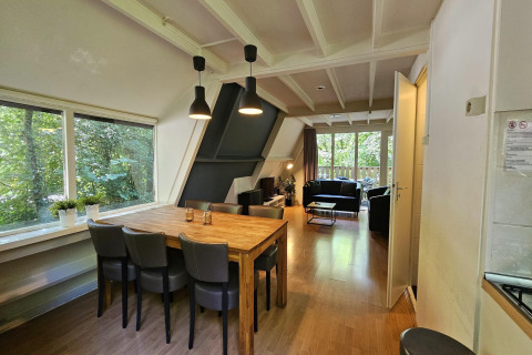 Innenansicht von Chalet Nr. 142 in Belgien mit Essbereich, Wohnzimmer und Blick ins Grüne.