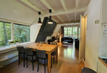 Innenansicht von Chalet Nr. 142 in Belgien mit Essbereich, Wohnzimmer und Blick ins Grüne.