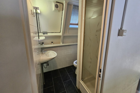 Kleines Badezimmer im Chalet no 142 Belgien mit Dusche, Waschbecken, WC und Fenster.