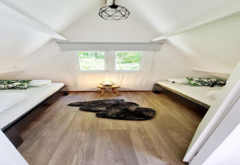 Helles Schlafzimmer im Chalet no 186 in Belgien mit zwei Einzelbetten, Fenstern und Holzdekor.