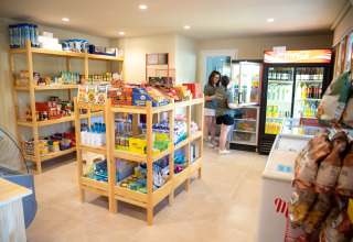 Dos mujeres comprando en una pequeña tienda de comestibles en TAIGA Lake Caspe, Aragón, España.