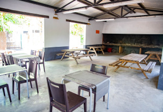 Espace repas avec tables et chaises au TAIGA Lake Caspe, parc de vacances en Aragón, Espagne.