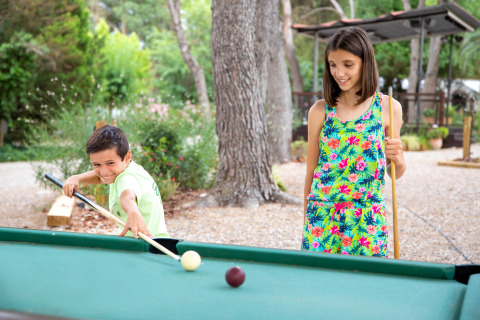 Deux enfants jouent au billard en plein air au parc de vacances TAIGA Lake Caspe en Aragón, Espagne, en été.