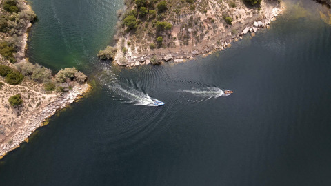 Vista aerea di barche sull’acqua vicino alla riva al TAIGA Lake Caspe, parco vacanze in Aragona, Spagna.