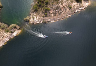 Vista aerea di barche sull’acqua vicino alla riva al TAIGA Lake Caspe, parco vacanze in Aragona, Spagna.