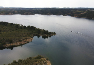 Veduta aerea del villaggio vacanze TAIGA Lake Caspe in Aragona, Spagna, circondato da acqua e natura.