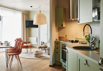 Bright living room and modern kitchen interior at The Easy Accessible Leaf lodge by YourNature resort.