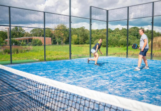Twee mensen spelen padel op een blauw veld bij The Easy Accessible Leaf by YourNature in België.