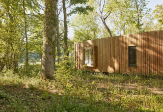 Piccola casa The Blue Lodge di YourNature, circondata da foresta in Belgio, vista esterna di giorno.