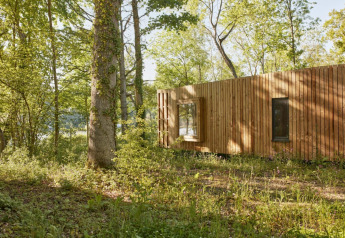Piccola casa The Blue Lodge di YourNature, circondata da foresta in Belgio, vista esterna di giorno.