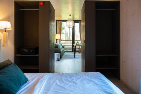 Vista dal letto a The Blue Lodge by YourNature in Belgio con armadi aperti e zona soggiorno sullo sfondo.