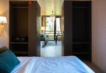 Vista dal letto a The Blue Lodge by YourNature in Belgio con armadi aperti e zona soggiorno sullo sfondo.