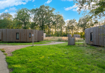 Photo de The Blue Lodge by YourNature, petits pavillons en bois entourés de verdure et d’arbres en Belgique.