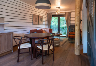 Gezellige woonkamer in The Cottage bij YourNature, met houten meubels en uitzicht op het bos.