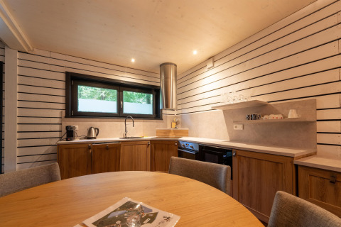 Moderne Glamping-Küche in The Cottage by YourNature mit Holzmöbeln und gemütlichem Essbereich.