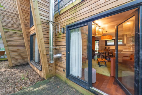 Houten glamping-accommodatie met grote ramen en buitenterras bij The Cottage van YourNature.