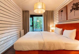 Alojamiento glamping The Cottage by YourNature con cama grande, decoración moderna y vistas al bosque.