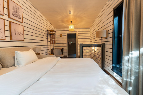 Vista interior de The Cottage en YourNature, una habitación glamping acogedora con decoración moderna y luz solar.
