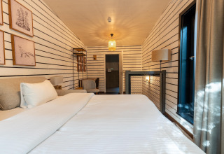Interieur van The Cottage bij YourNature, een knusse glampingkamer met moderne inrichting en zonlicht.