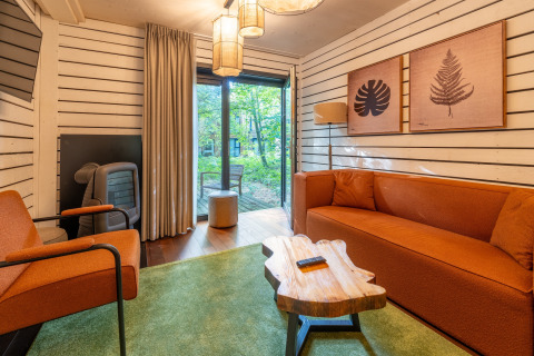 Moderne woonkamer in The Cottage by YourNature in België met oranje meubels en uitzicht op het bos.