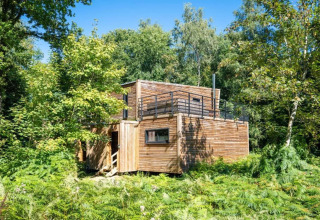 Casa de naturaleza 'The Cottage by YourNature' en Bélgica, una cabaña moderna entre vegetación.