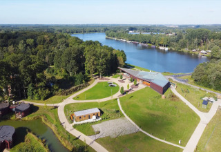 Luftaufnahme der Lodge by YourNature, einem Tiny House in Belgien, mit See und viel Grün.