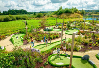 Minigolfplatz inmitten grüner Natur bei The Lodge by YourNature in Belgien, Menschen spielen.