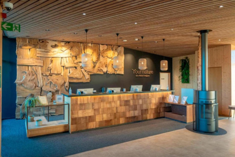 Rezeption der Lodge The Easy Accessible Leaf by YourNature in Belgien, mit Holzdekor und gemütlicher Atmosphäre.