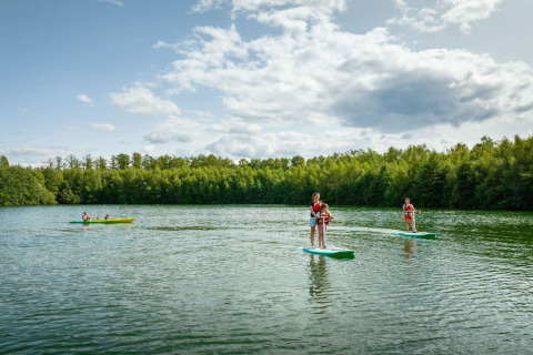 Gäste paddeln und stehen auf Paddleboards auf einem See bei The Easy Accessible Leaf by YourNature in Belgien.