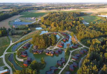 Aerial view of The Large Leaf by YourNature lodge in Belgium, surrounded by forests, lakes, and fields.