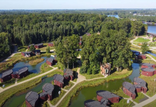 Aerial view of The Large Leaf by YourNature lodge in Belgium, surrounded by forest, cabins, and ponds.