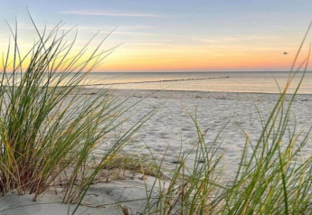 Zonsondergang en zeezicht vanaf het strand bij Houseboat «in Peenemünde» in Duitsland.